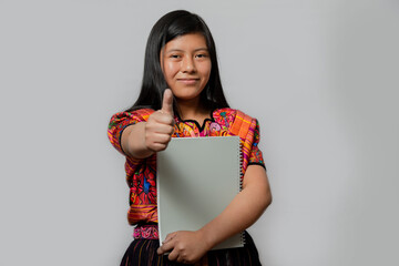 Hispanic young woman with notebook and thumb up - Mayan teenager ready to go to study - Latina...