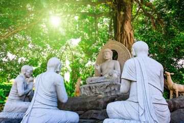 Stone carving of Buddha under the tree.