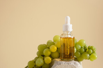 on a concrete podium a yellow background, grape seed cosmetics, oils and serums in a bottle with a pipette