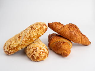 Baked goods croissant and cheese bun on white background.