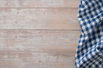 Fototapeta na wymiar Wooden table and blue checkered tablecloth