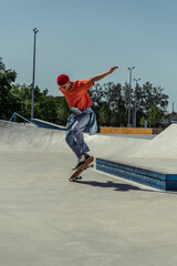 young man in trendy summer outfit jumping with skateboard
