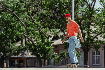 full length of man in stylish outfit skateboarding in blurred city park