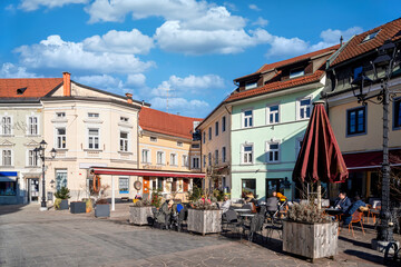 Obraz premium The main street in Kranj with people sitting in a cafe on a sunny day in Winter. Slovenia