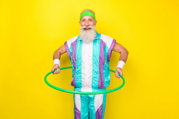 Portrait of positive cheerful person hold hula-hoop weight loss warm up isolated on yellow color background