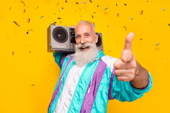 Portrait Of Positive Excited Aged Person Hold Boombox Pointing Finger You Enjoy 90s Vibe Isolated On Yellow Color Background