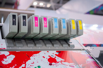 Row of inkjet printer CMYK cartridges - cyan, magenta, yellow, key or black colors - close up view.
