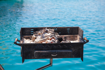 Barbecue on the blue sea, fiery coal embers. Boat dinner.