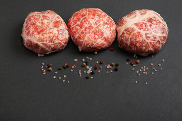 minced meat cutlets in a thin fatty mesh shell is ready for use, semi-finished products in a fat grid, copy space.