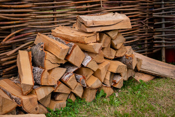 Stacked chopped triangle firewood for fireplace on ground - outdoor, summer time