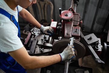 Close-up of an Asian technician inspecting and operating a machine in an industrial facility. industrial workers working in factories The concept of industrial production.