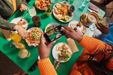 High angle view of woman taking picture of food in restaurant © Faces of Travel