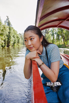 Thoughtful young woman sitting in trajinera boat