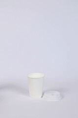 cardboard glass and a lid next to it on a white background. High quality photo