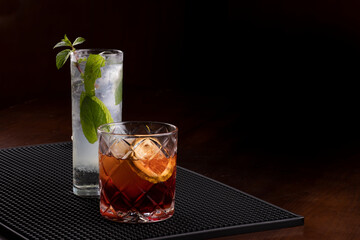 Two bartender cocktails mojito and negroni in professional support