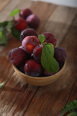 Fresh plum. Harvest. Autumn harvest. Blue plums. Plums on a wooden surface. Fresh plums on wooden table background.