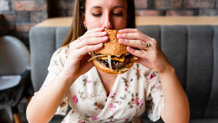Burger girl eat. Hungry Caucasian Woman Eating Tasty Hamburger. Junk Food Concept.