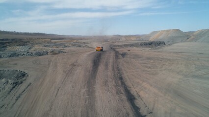 Drone camera follows a dump truck loaded with quarry coal. Truck is symbol of mining industry © planarfilm
