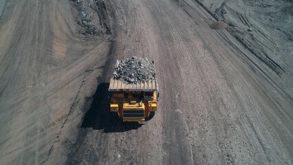 Drone camera follows a dump truck loaded with quarry coal. Truck is symbol of mining industry © planarfilm
