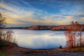 Pastel Sky at Sunset.   The smooth surface of the lake water creates a muted reflection of the...