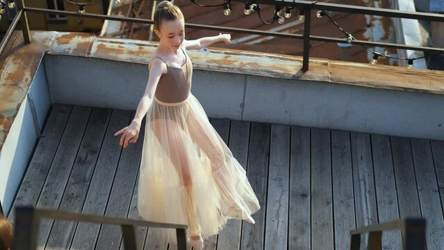 girl dancing ballet on the roof of the house