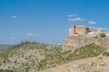 Fototapeta premium Vista panorámica de Moscardón al borde de un barranco en Teruel con su Iglesia de San Pedro Apóstol sobresaliendo sobre la población