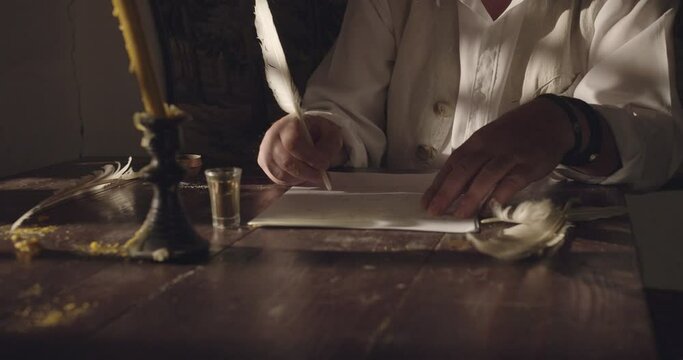 Hands of a male person while writing document tex on papyrus in the night time, action scene, crane shot, close-up.