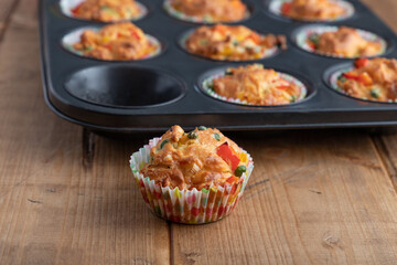 vegetable muffins in a baking form with pepper, corn and zucchini, focus on foreground