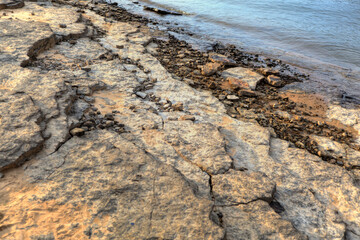 Long exposure of Rocks and sand on the bank of a lake