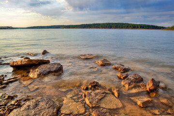 Long exposure of Rocks and sand on the bank of a lake