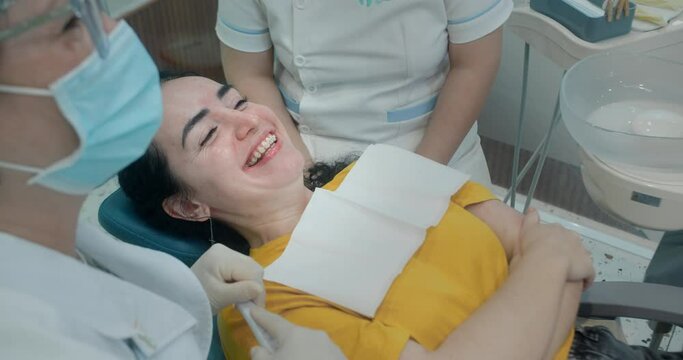 Woman dentist with a patient in dental office are happy about result installation of braces and teeth alignment. Dentistry very happy. Close-up female teeth with brackets. Health and medicine concept