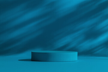 Round cylinder podium for products or cosmetics against dark blue background with leaves shadows.