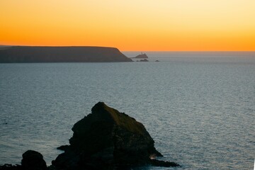 Seascape in Bassett Cove Cornwall Coast with rocks in the water at sunset