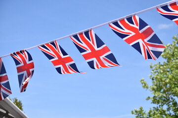 Fototapeta na wymiar Small UK flags on a string in London street. Union Jack flags in the wind