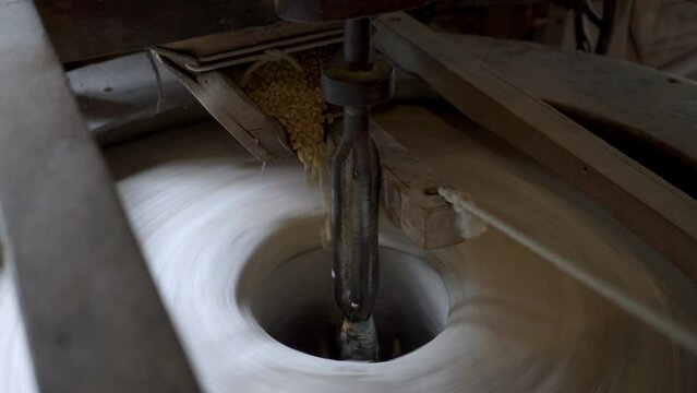 Gristmill stone grinding corn to grits. 