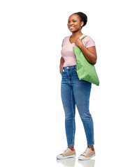 sustainability and people concept - happy smiling young african american woman with green reusable canvas bag for food shopping walking over white background