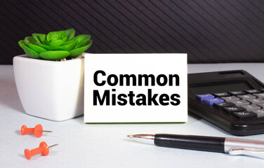 On the table against the background of books is a business card with the inscription - Common...