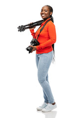 Naklejka premium people, profession and photography concept - happy young woman with digital camera and tripod over white background
