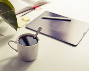 workplace background with cup of coffee and tablet over white table