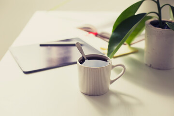 workplace background with cup of coffee and tablet over white table