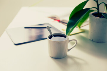 workplace background with cup of coffee and tablet over white table
