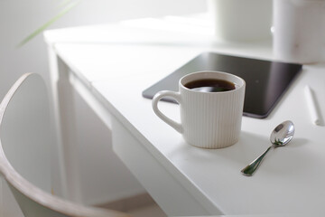 workplace background with cup of coffee and tablet over white table
