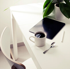 workplace background with cup of coffee and tablet over white table