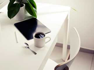workplace background with cup of coffee and tablet over white table