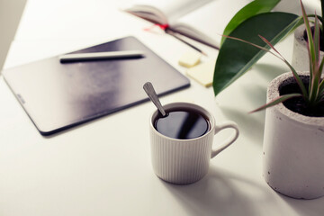 workplace background with cup of coffee and tablet over white table