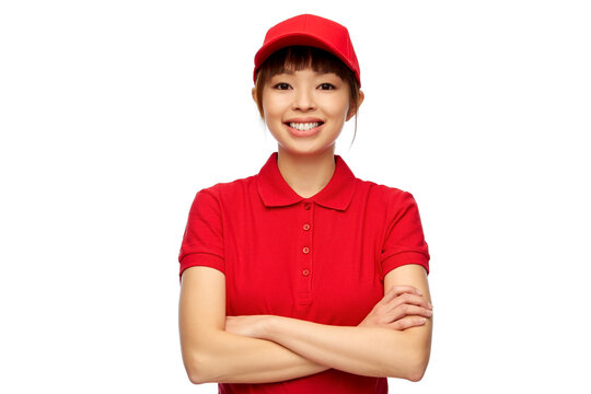 profession, job and people concept - happy smiling delivery woman in red uniform with crossed arms over white background