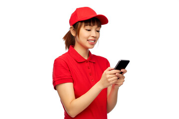 profession, job and people concept - happy smiling delivery woman in red uniform with smartphone over white background