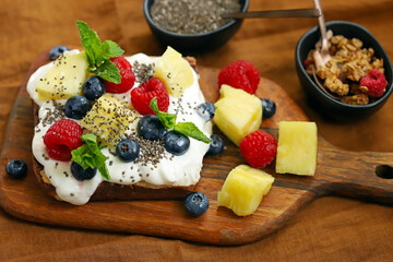 Cake with yogurt and fruits on a wooden board. Summer dessert.
