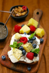 Cake with yogurt and fruits on a wooden board. Summer dessert.