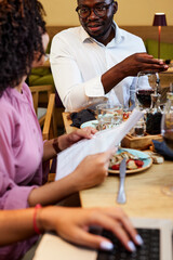 The colleagues at the dinner table in the restaurant sit and have a business meeting and brainstorm.